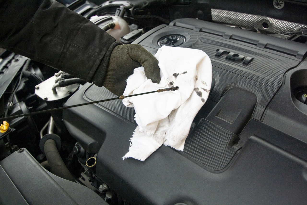 A mechanic checking the oil levels on a car